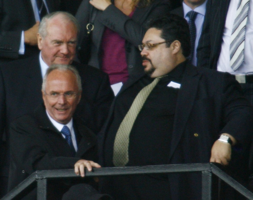 Three men in suits at a football match.