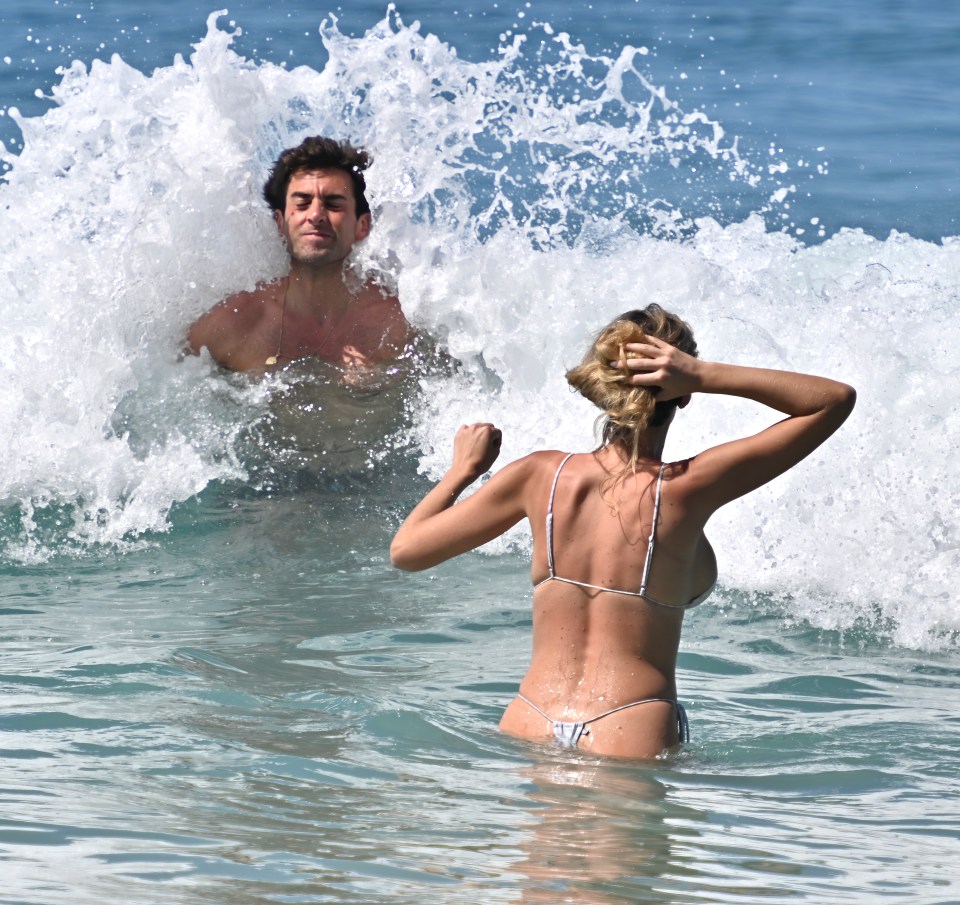 James Argent and Nicoline Artursson playing in ocean waves.