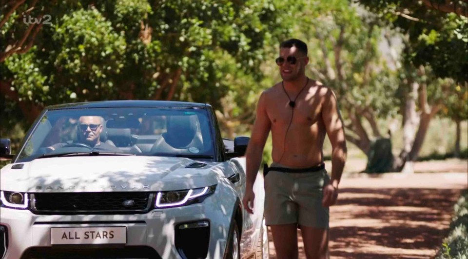 A shirtless man walks past a white Range Rover convertible labeled "All Stars."