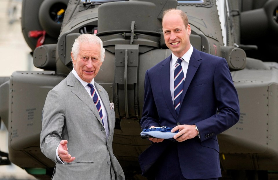 King Charles III and Prince William in front of a helicopter.