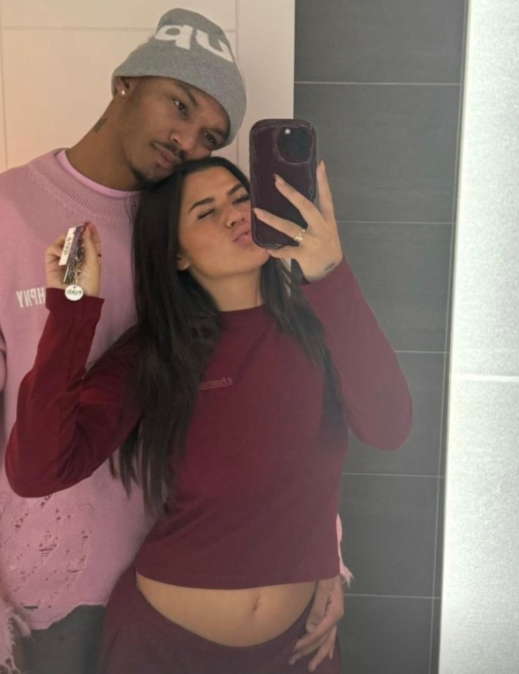 Couple taking a selfie in a bathroom; the woman is holding keys.