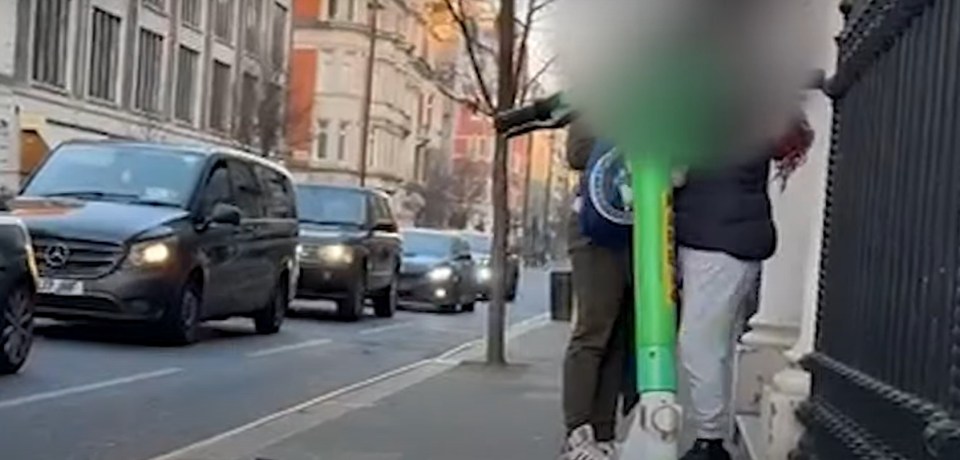 Screenshot of a video showing a person on a scooter on a city street.