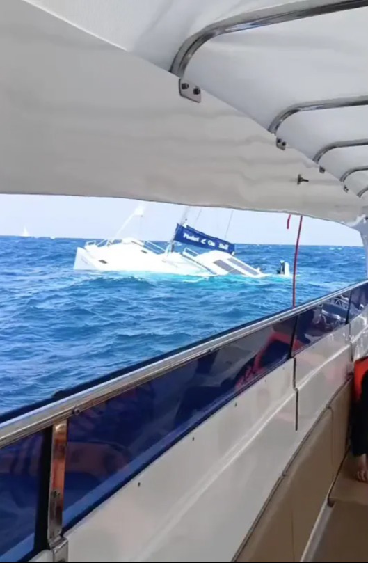 Video still of a catamaran sinking in the ocean.