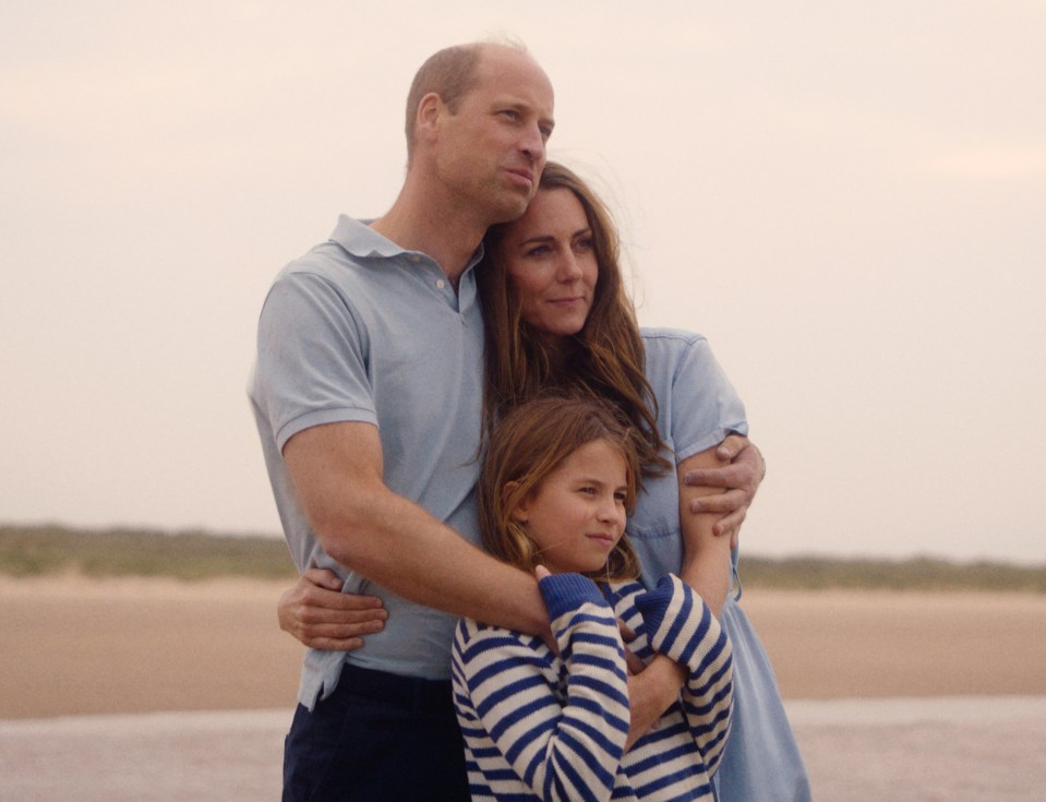 The Prince and Princess of Wales and Princess Charlotte on a beach.