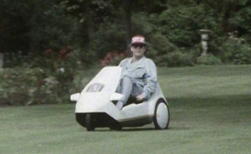 Elton John driving a Sinclair C5.