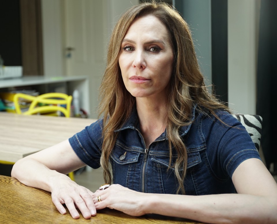 Woman in denim jacket sitting at a table.