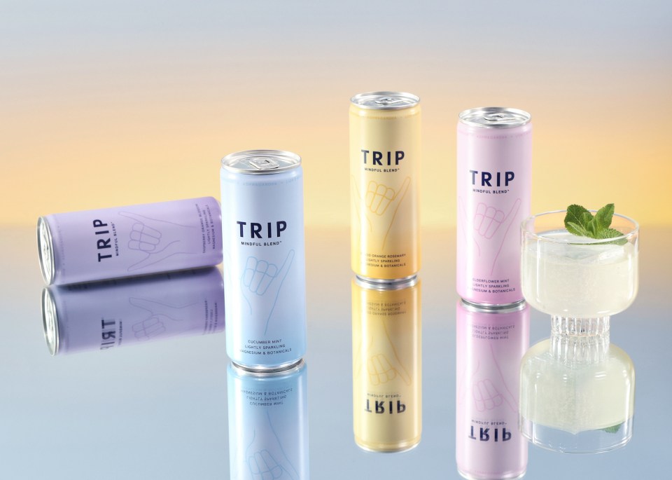 Four cans of TRIP Mindful Blend, in flavors raspberry orange blossom, blood orange rosemary, elderflower mint, and cucumber mint, alongside a glass of the beverage.