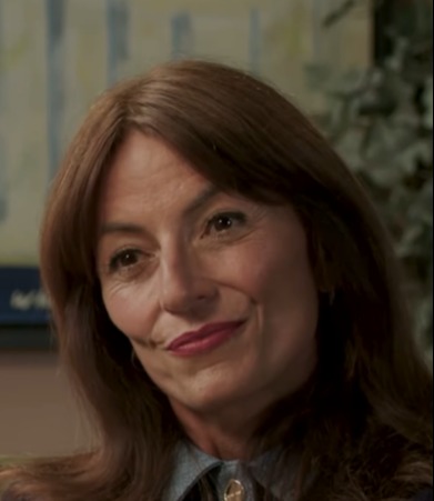 Woman speaking, wearing a necklace.