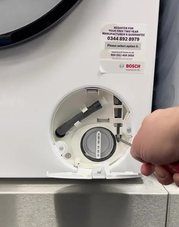 Unlocking a washing machine's hidden button.