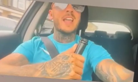 Man with tattoos speaking in a car.