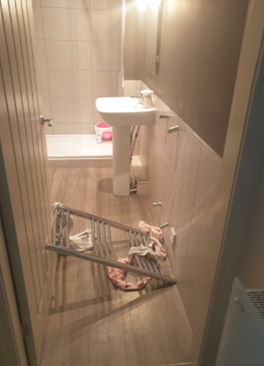 Bathroom with fallen towel rack.