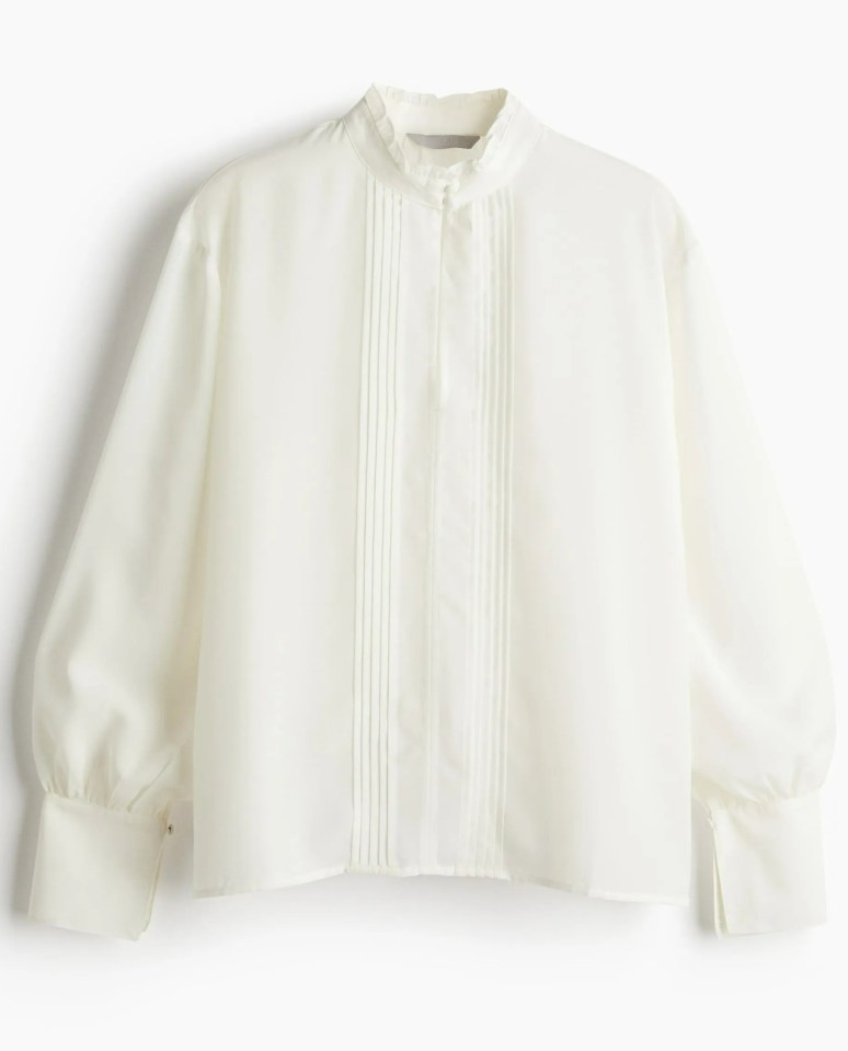 Cream-colored blouse with long sleeves and pleated front.