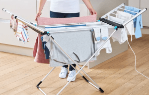 Person loading clothes onto an electric heated clothes airer.