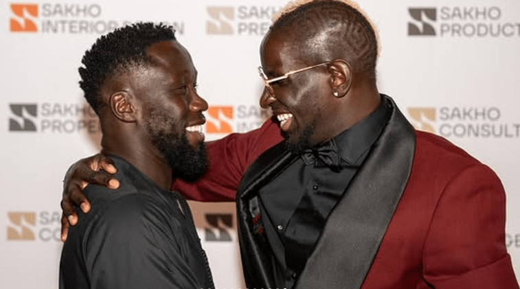 Two men smiling and embracing.