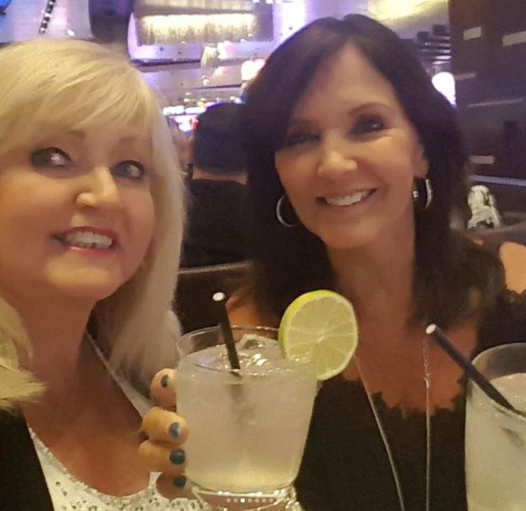 Two women enjoying cocktails.