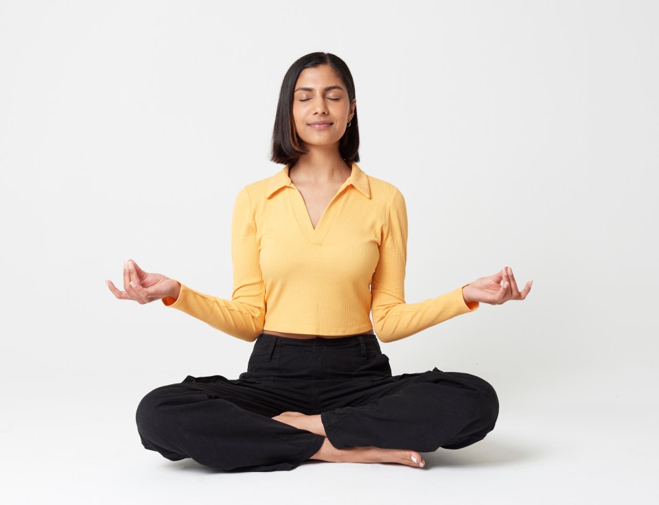 Woman meditating in a cross-legged seated position.