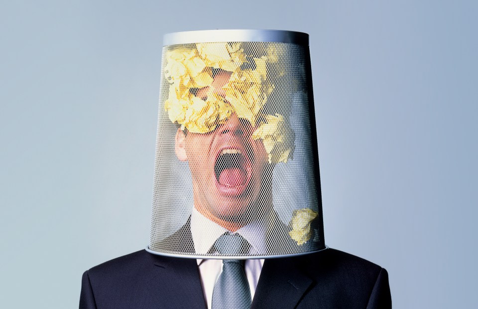 Businessman with wastepaper bin on his head.