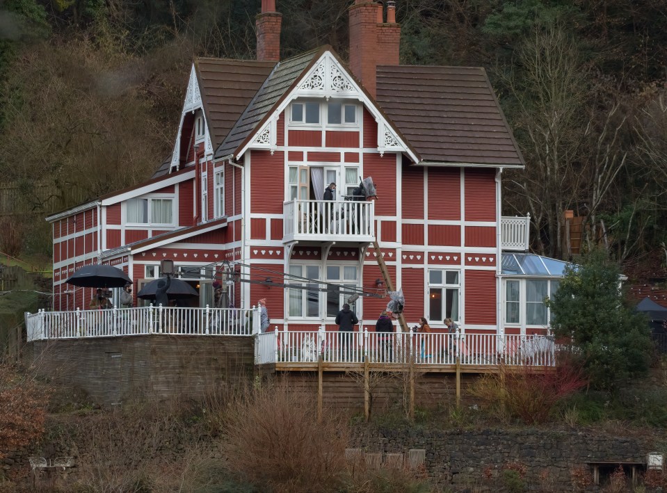 17 February 2021 - EXCLUSIVE. Aimee Lou Wood and Samantha Spiro are seen filming scenes for Sex Education Series 3. Samantha Spiro (Mrs Groff) aided by Aimee Lou Wood (Aimee Gibbs) appear to be breaking into the Chalet via a ladder to the upstairs balcony and goes over head first, legs in the air. Credit: GlosPics/GoffPhotos.com Ref: KGC-267 **Exclusive to GoffPhotos.com - Newspapers Allrounder - Magazines Double Space Rates - Online/Web Must Call Before Use**