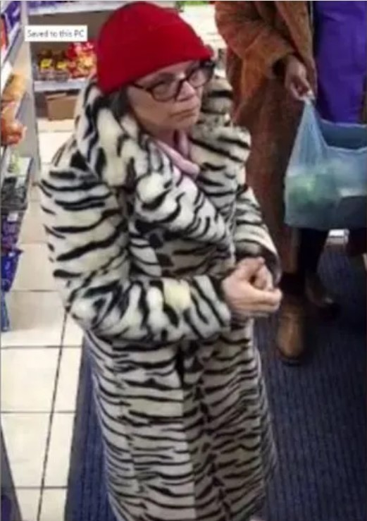 Surveillance image of Lynda wearing a zebra-striped coat and red hat.