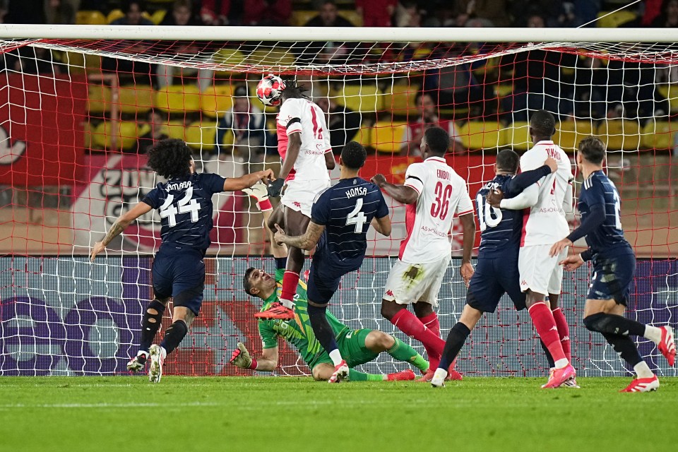 Monaco's Wilfried Singo, top, scores the opening goal of his team during a Champions League opening phase soccer match at the Louis II stadium in Monaco, Thursday, Jan. 21, 2025. (AP Photo/Laurent Cipriani)