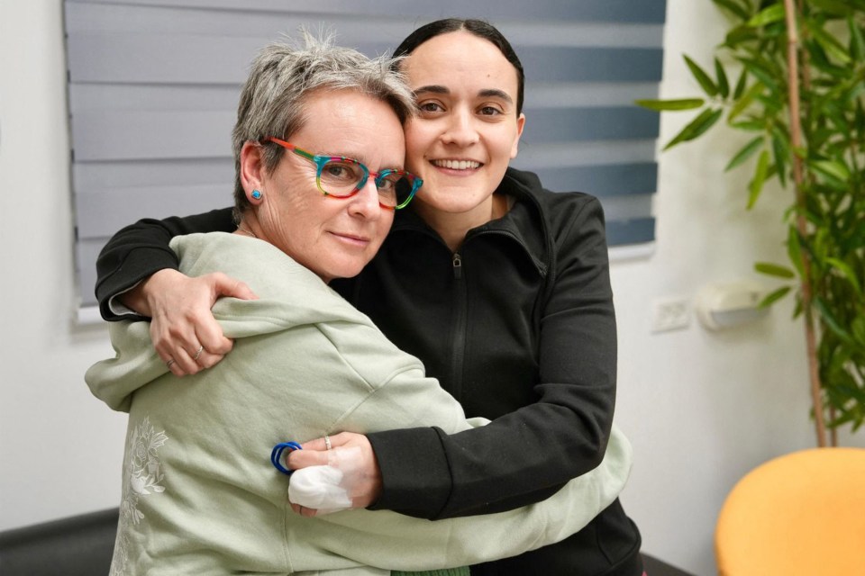 This handout picture released by the Israeli army shows former Israeli hostage Emily Damari with her mother Amanda at an undisclosed location in Israel on January 19, 2025 after a ceasefire and hostage-prisoner exchange deal in the war between Israel and Hamas was implemented. The first three Israeli hostages were released on January 19 under a long-awaited Gaza truce aimed at ending more than 15 months of war that has ravaged the Palestinian territory. The Hostage and Missing Families Forum campaign group had identified the three women set to be released as Emily Damari, Romi Gonen and Doron Steinbrecher. (Photo by Israeli Army / AFP) / === RESTRICTED TO EDITORIAL USE - MANDATORY CREDIT "AFP PHOTO / Handout / Israeli Army' - NO MARKETING NO ADVERTISING CAMPAIGNS - DISTRIBUTED AS A SERVICE TO CLIENTS == (Photo by -/Israeli Army/AFP via Getty Images)