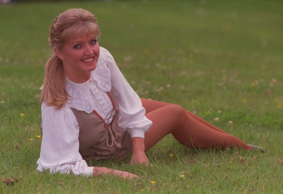 Woman sitting in grass smiling.