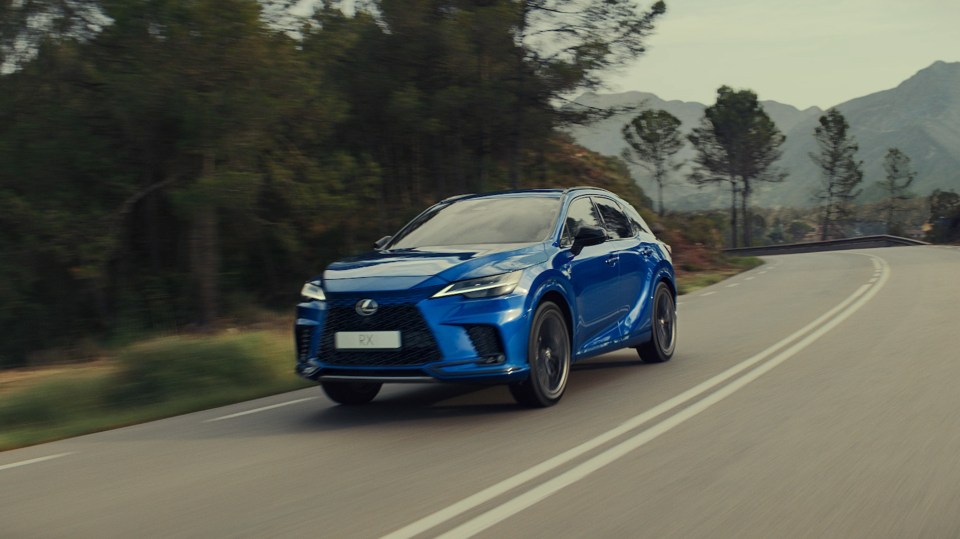 Blue Lexus RX 450H driving on a winding road.