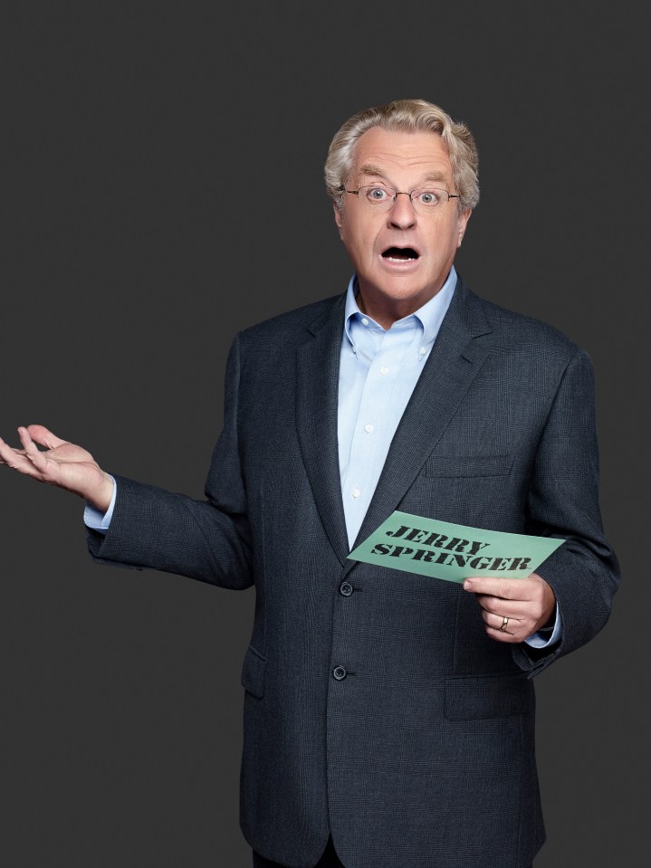 Jerry Springer holding a card with his name on it.