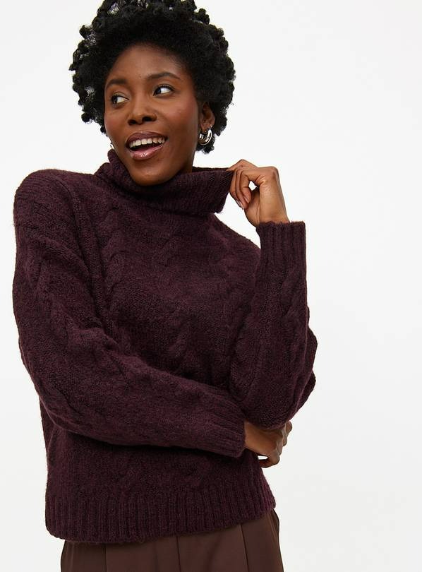 Woman in a maroon cable knit turtleneck sweater.