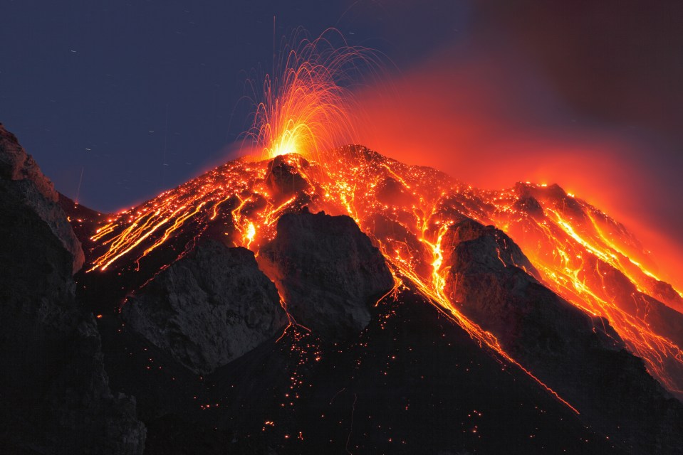 Lava flowing down a volcano at night.