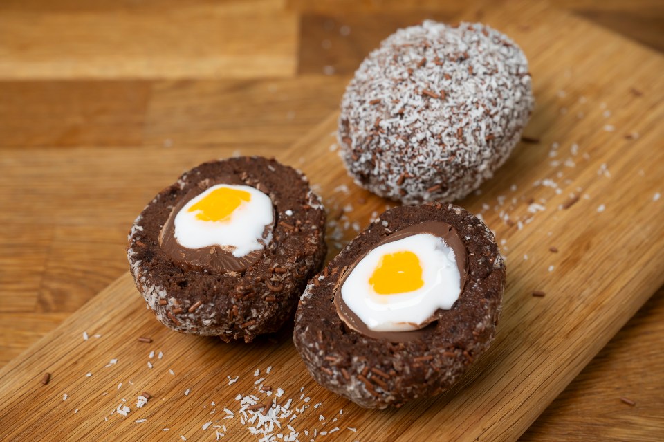 Chocolate coconut treats cut in half, revealing a creamy white and yellow center.