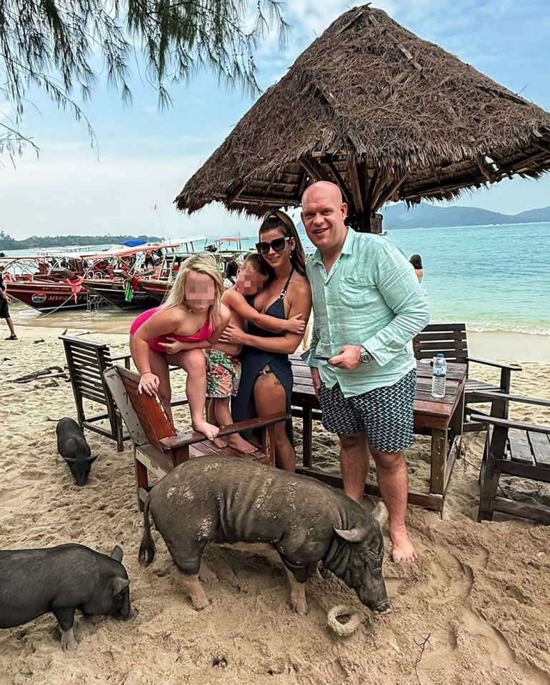 Family on a beach with pigs.