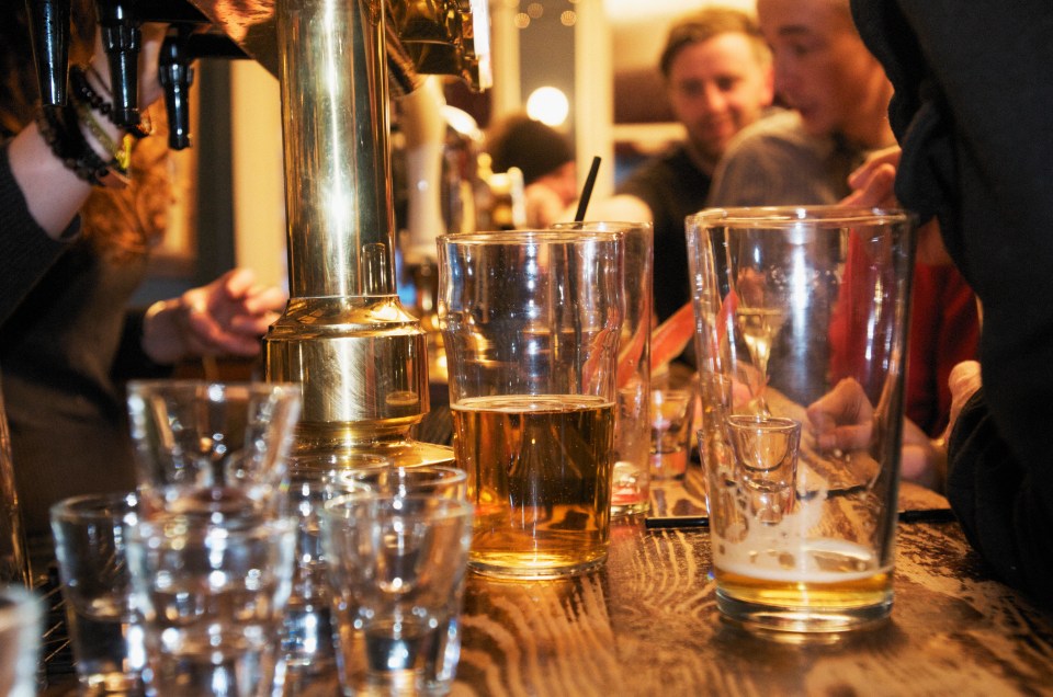 Beer glasses and shot glasses on a bar counter.