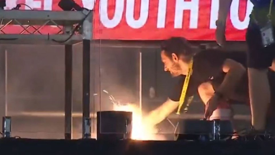 Person lighting a small fire on a stage.