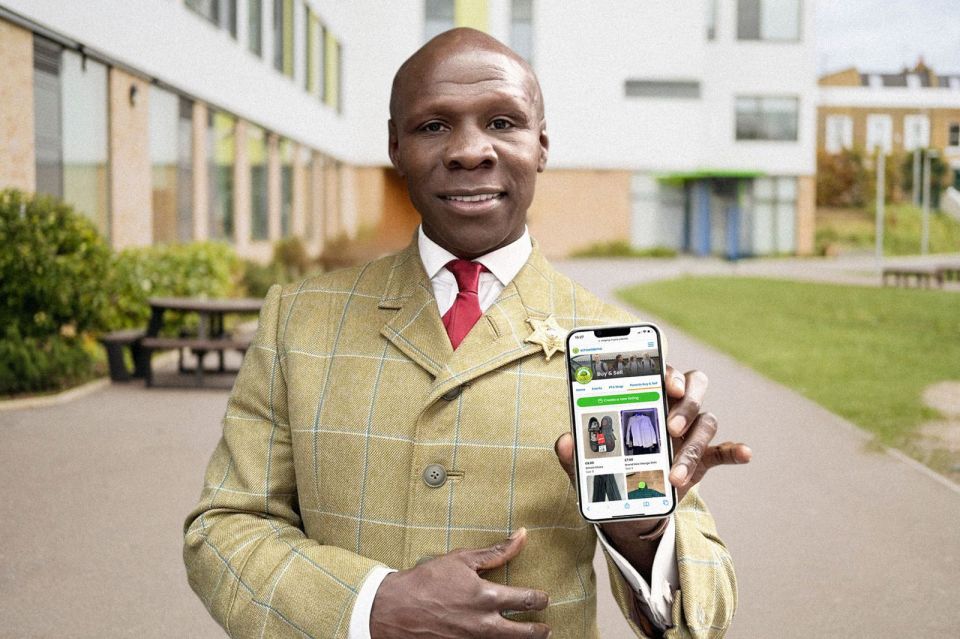 Man in a tweed jacket holding a smartphone displaying a school uniform marketplace app.