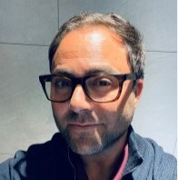 Headshot of a man wearing glasses.