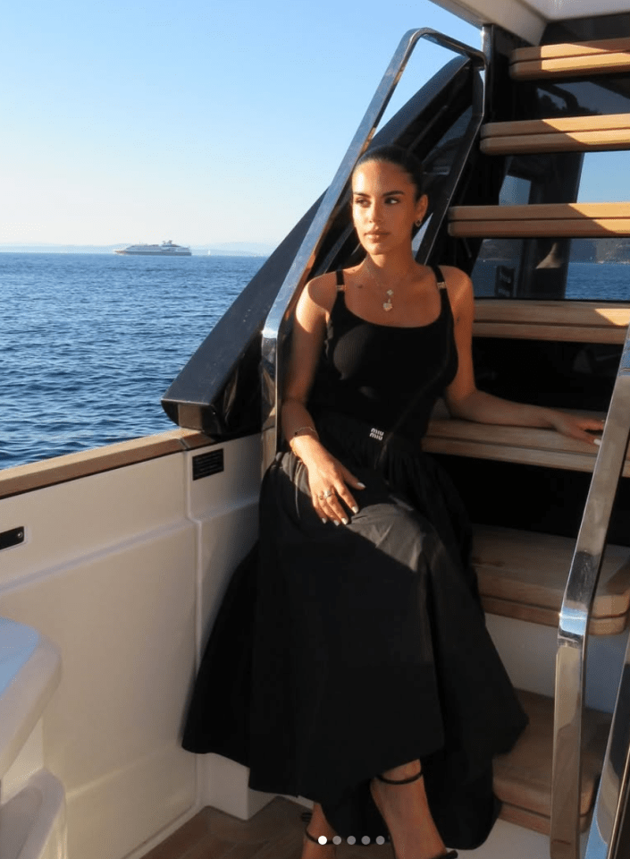 Woman in black dress on a yacht.