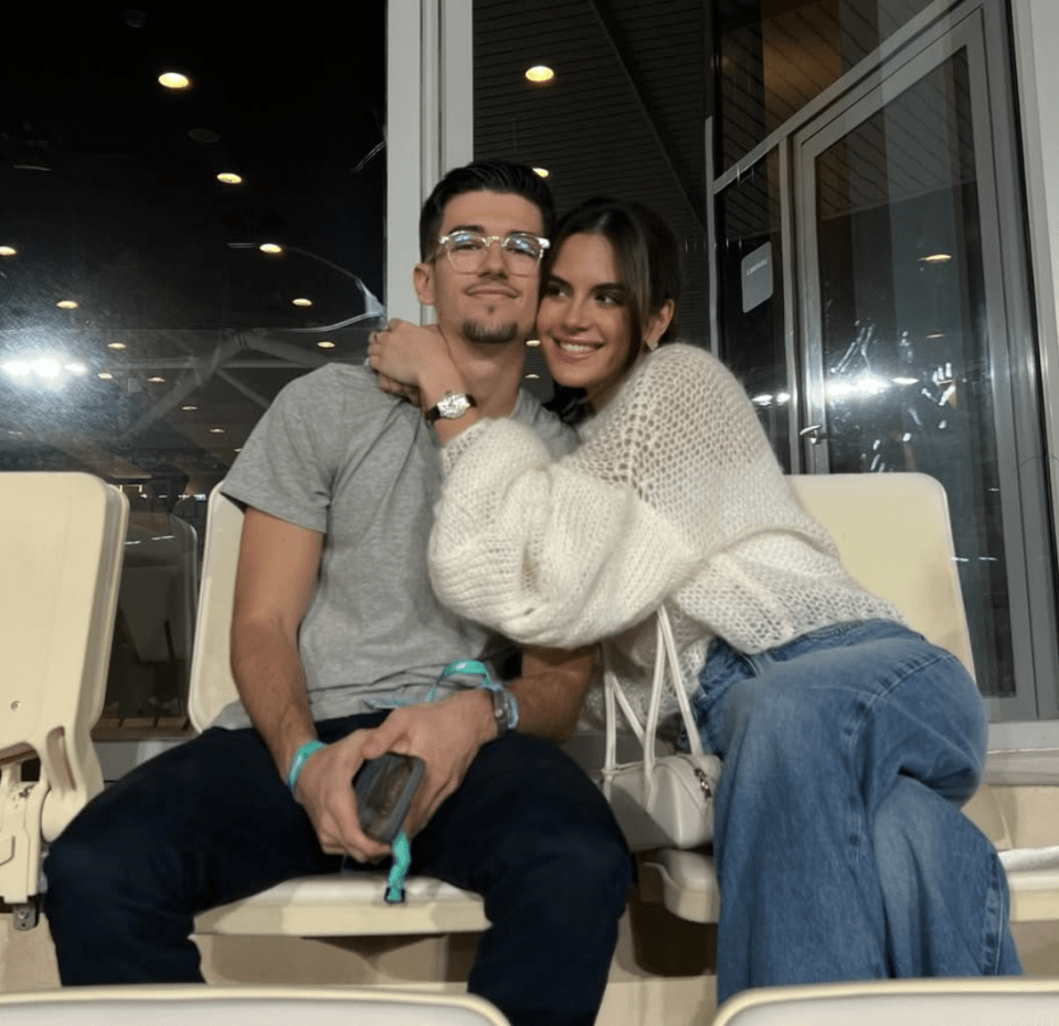 Couple embracing in stadium seats.