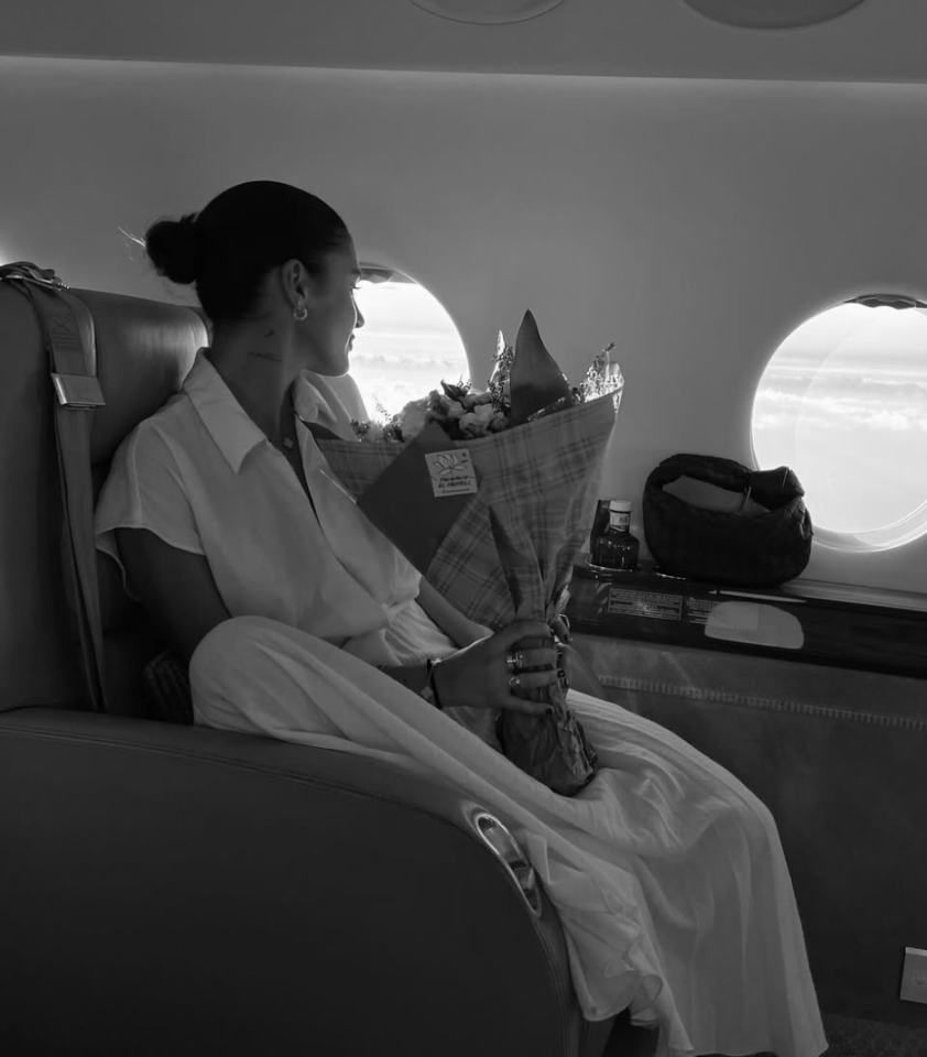 Woman holding flowers on a private jet.