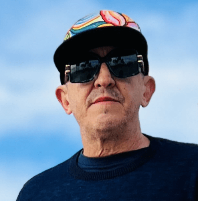 Man wearing sunglasses and a colorful cap.