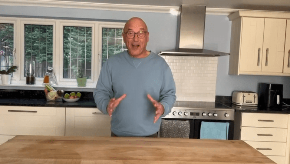 Man in a blue sweater standing in a kitchen.