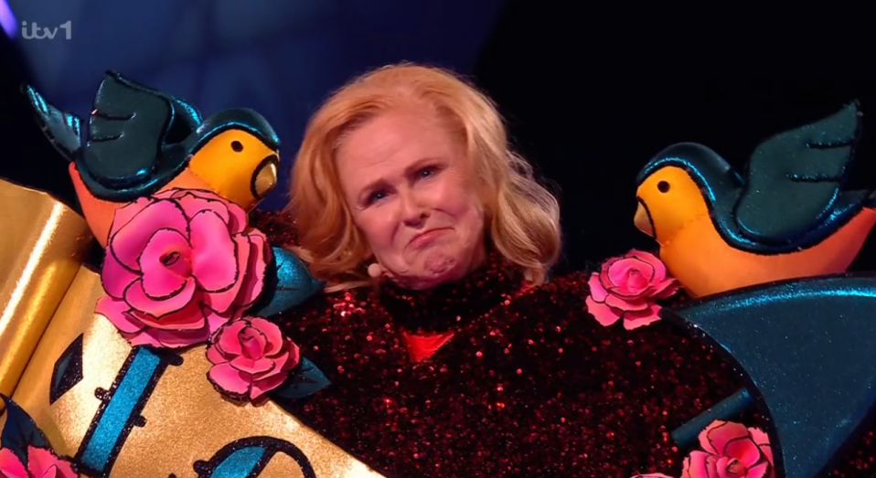 A woman in a sparkly red costume with birds and roses.