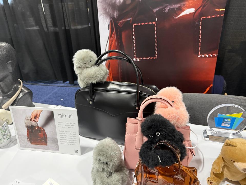 Would you have a furry robot cling to your handbag?