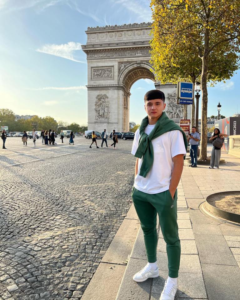 Person standing in front of the Arc de Triomphe in Paris.