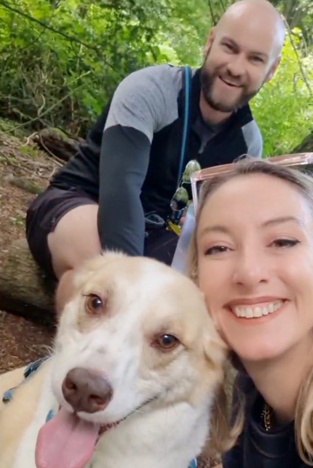 Woman and man with their dog in a park.