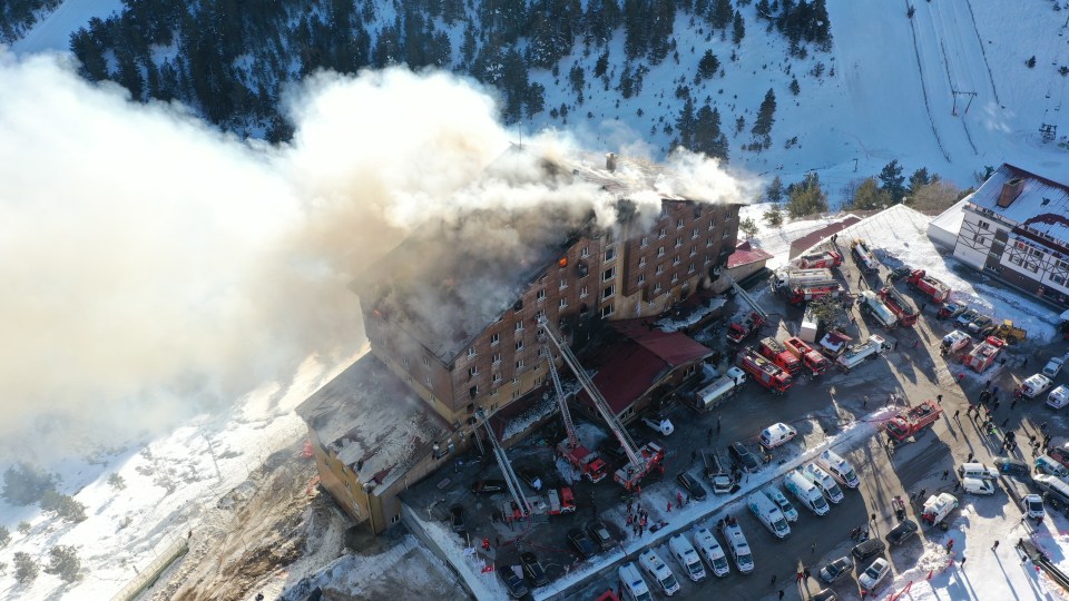 Aerial view of a hotel fire with fire trucks and ambulances responding.