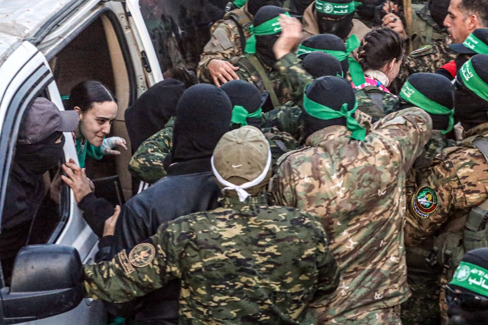 Al-Qassam Brigades members hand over an Israeli hostage to the Red Cross.