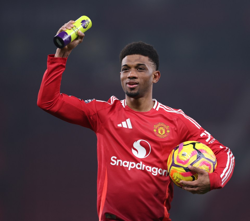 Amad Diallo of Manchester United celebrates with the match ball and Player of the Match trophy.