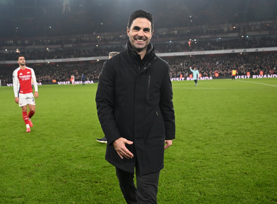 Mikel Arteta, Arsenal manager, smiling on the pitch after a match.