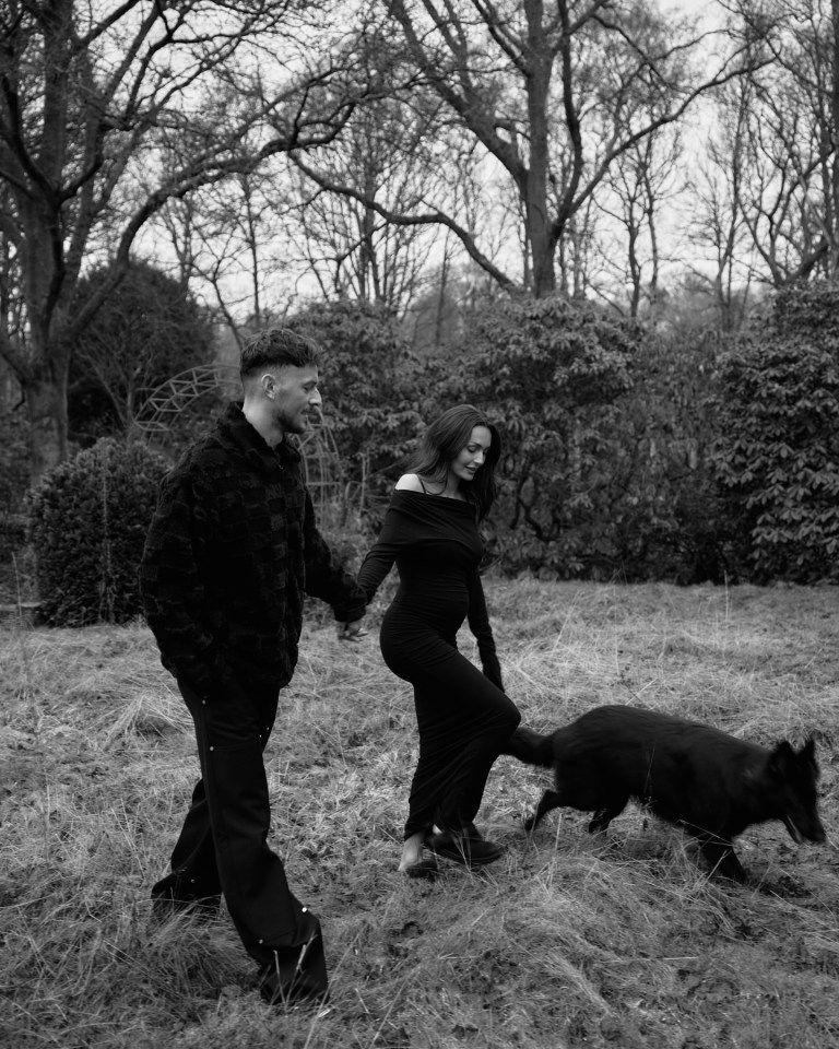 Ben White and his wife walking in a field with their dog.